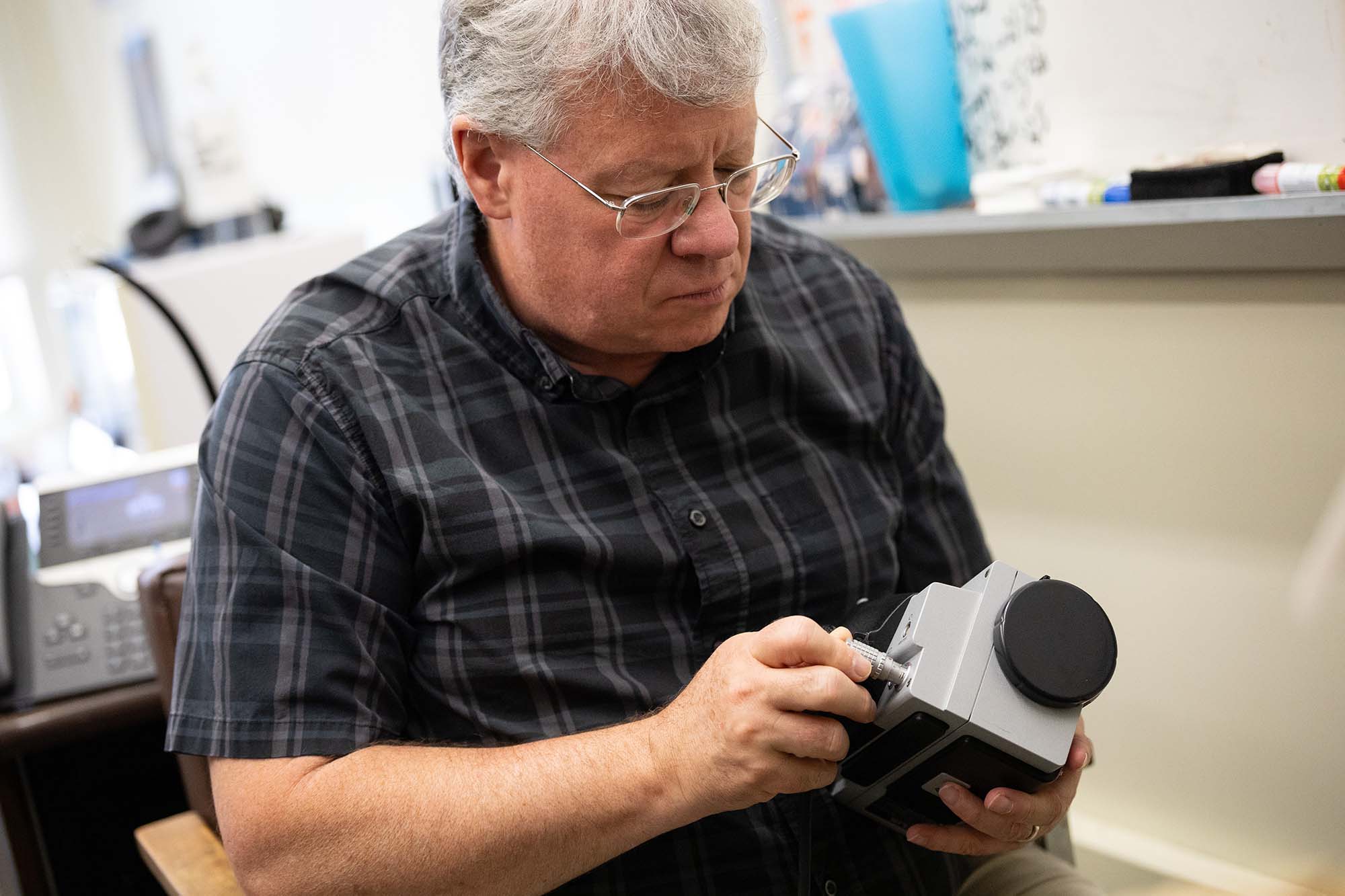 Kevin Knuth holds a device to study unidentified anomalous phenomena.