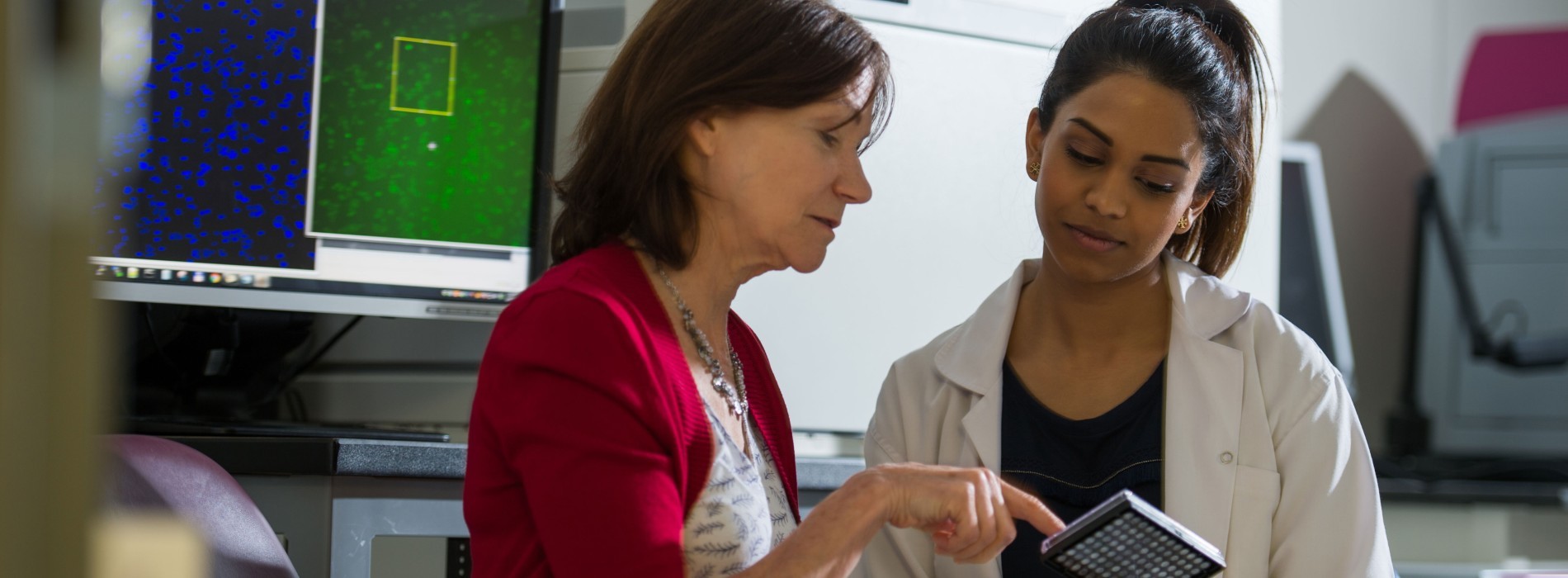 Two women collaborate inside a research laboratory.