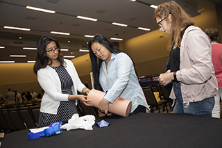 Last year's summit included students (l to r) Elizabeth Kaufman, Adriana Ng and Sandra Hernandez practicing tourniquet techniques in “Stop the Bleed” training.