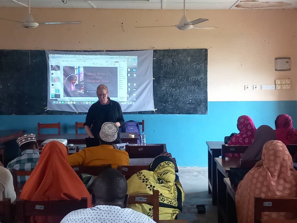 Angel Ford stands in front of a classroom of teachers during a training session in Tanzania.