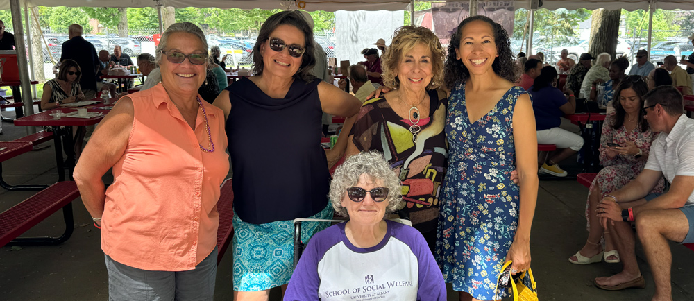 Alumni and staff from the UAlbany School of Social Welfare pose for a photo under a tent at Saratoga Race Course.