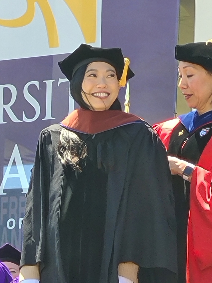 Nora Lum is hooded by UAlbany Provost Carol Kim as she receives her honorary doctorate at UAlbany's commencement ceremony.