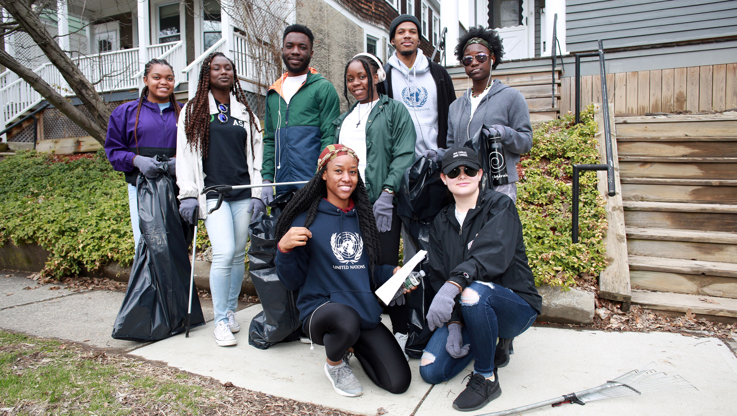 Eight students pose for a photo during a neighborhood clean-up event.