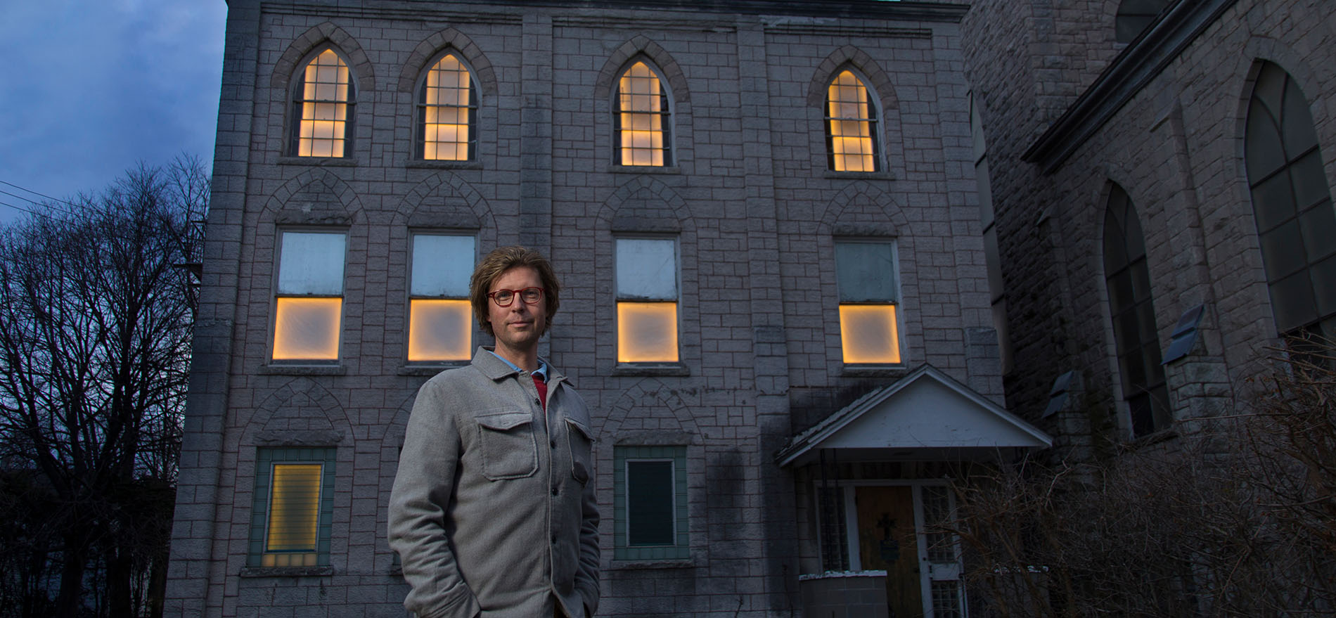Professor Adam Frelin stands in front of one of the buildings included in his public art project entitled 'Breathing Lights'. The multi-city installation transforms abandoned structures into glowing places of warmth. Photographer: Paul Miller
