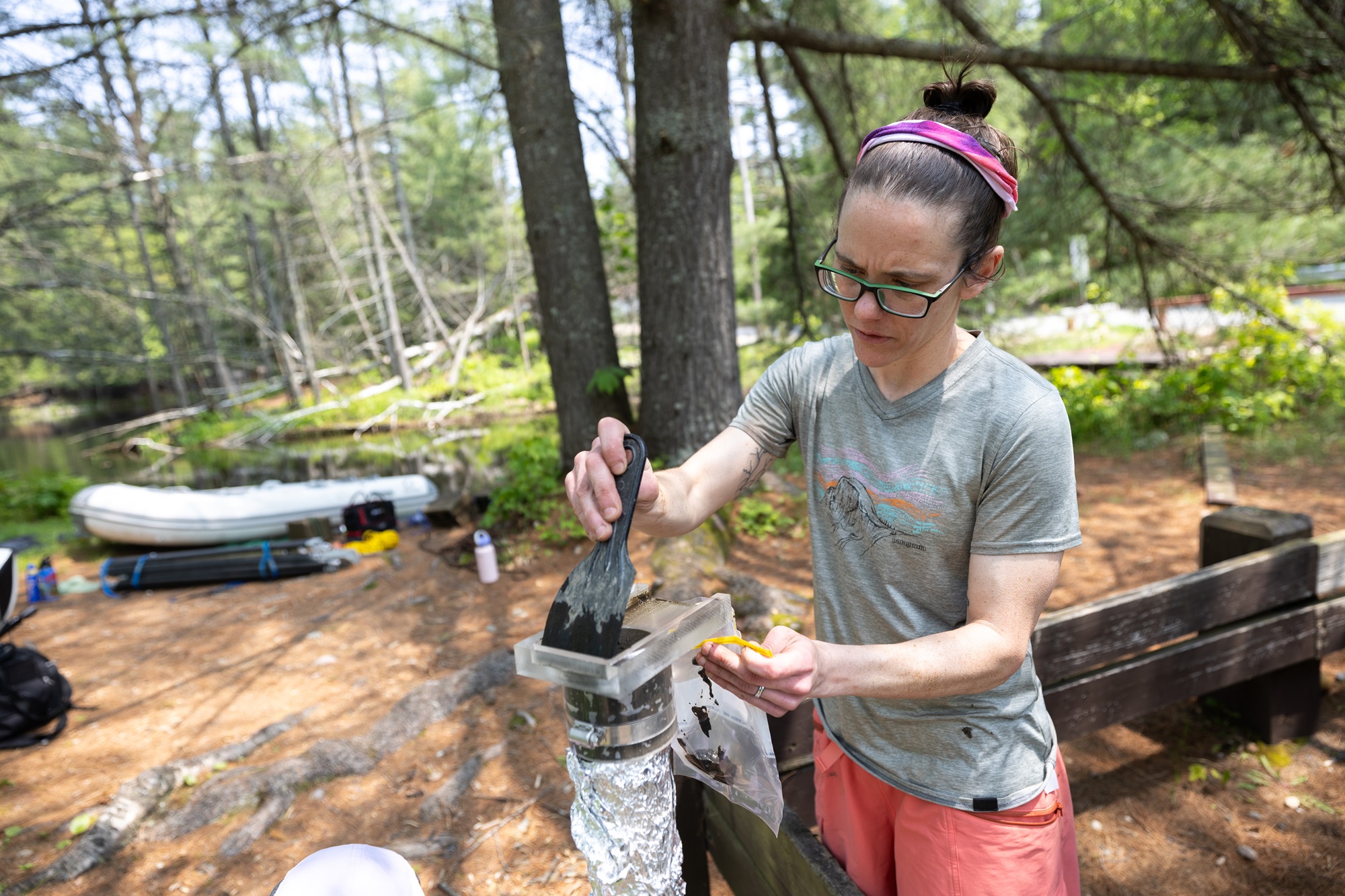 Aubrey Hillman scrapes layers from the sediment core to prepare them for data collection.