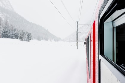 A bus travels through a snowy landscape.