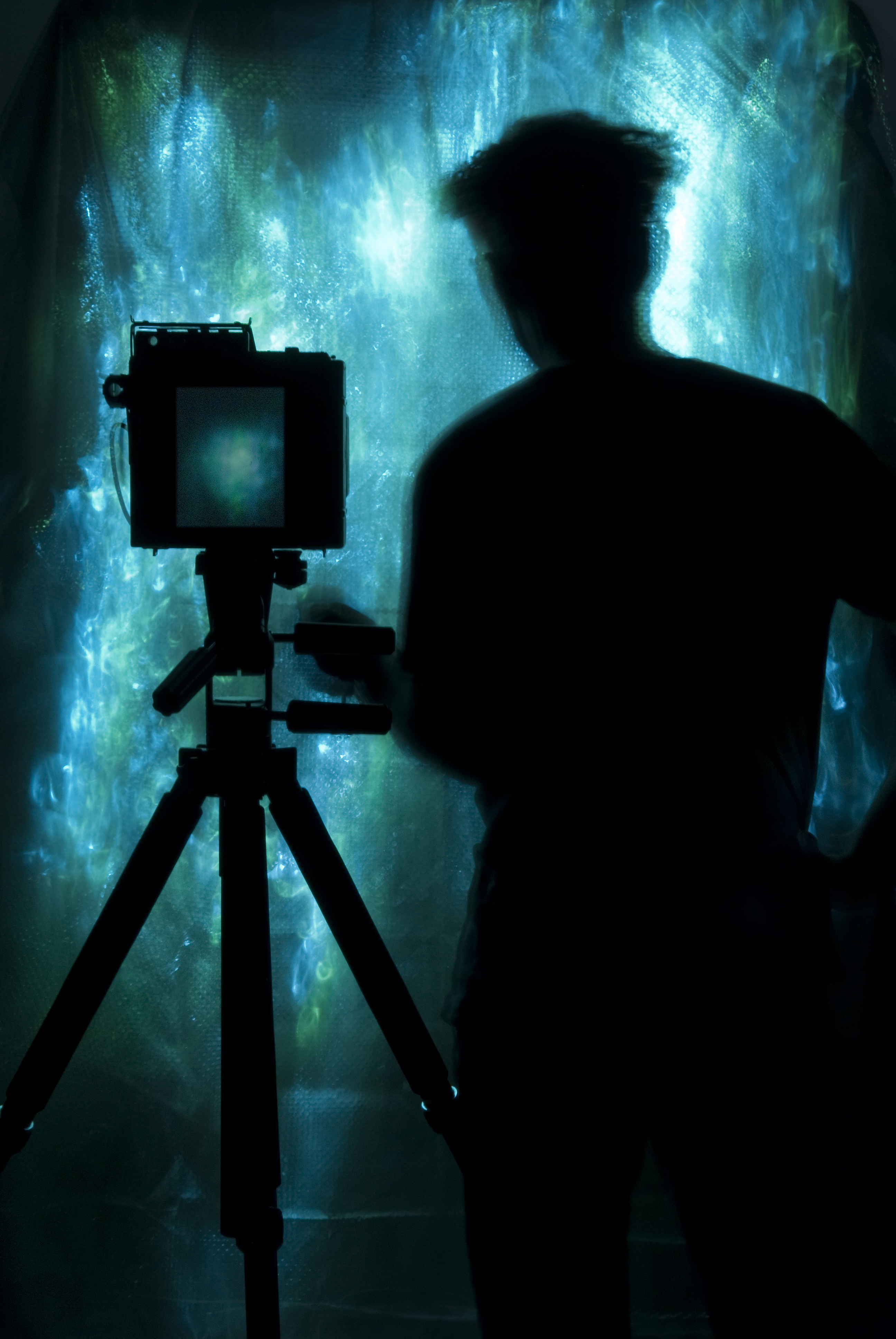 silhouette of a man with a camera on tripod