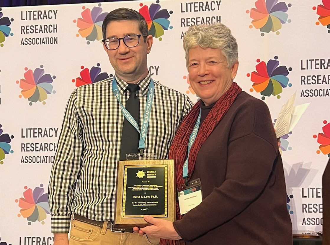 man and woman posing with award plaque