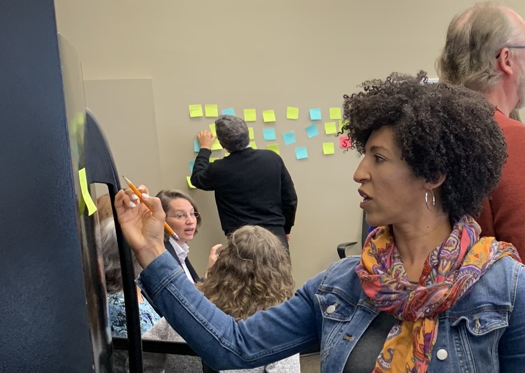 individual in scarf writing on a board