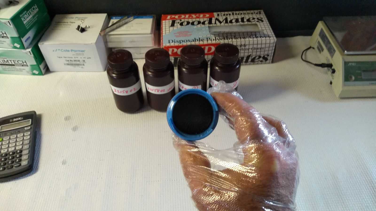 A researcher at UAlbany's Whiteface Mountain Field Station holds a black-colored cloud water sample.