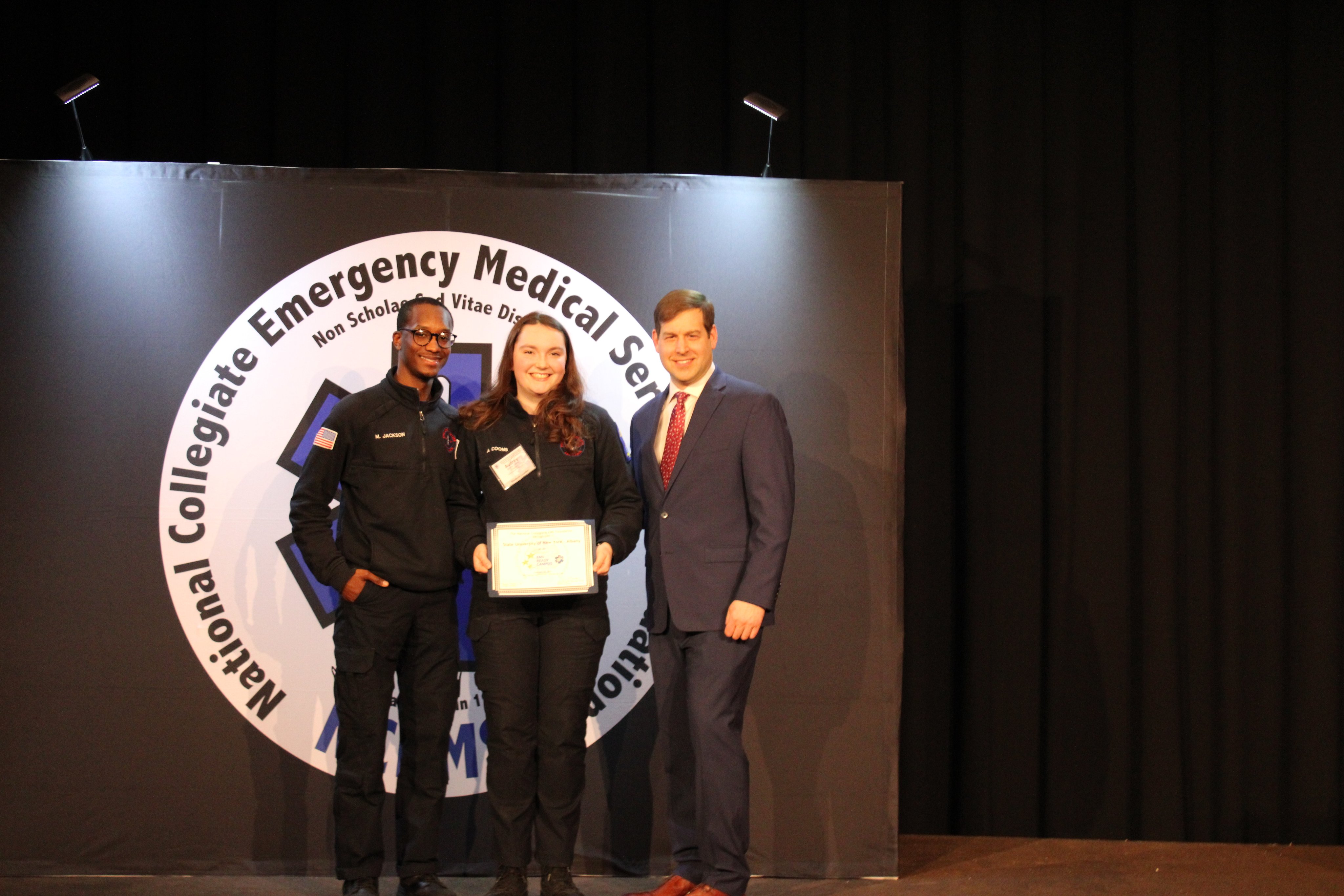 Five Quad's Audrey Coons holds up the “EMS Ready Campus" Gold Tier award.