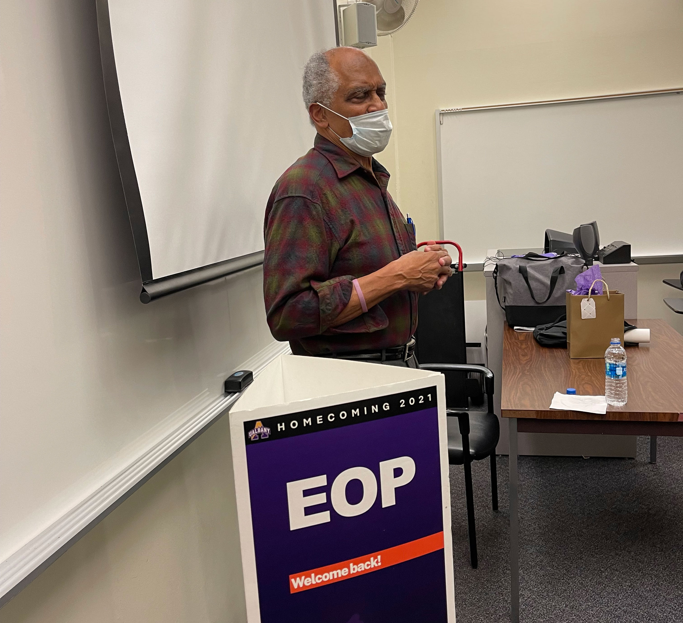 Dr. Harry Hamilton speaks in front of a whiteboard and EOP Homecoming 2021 sign.