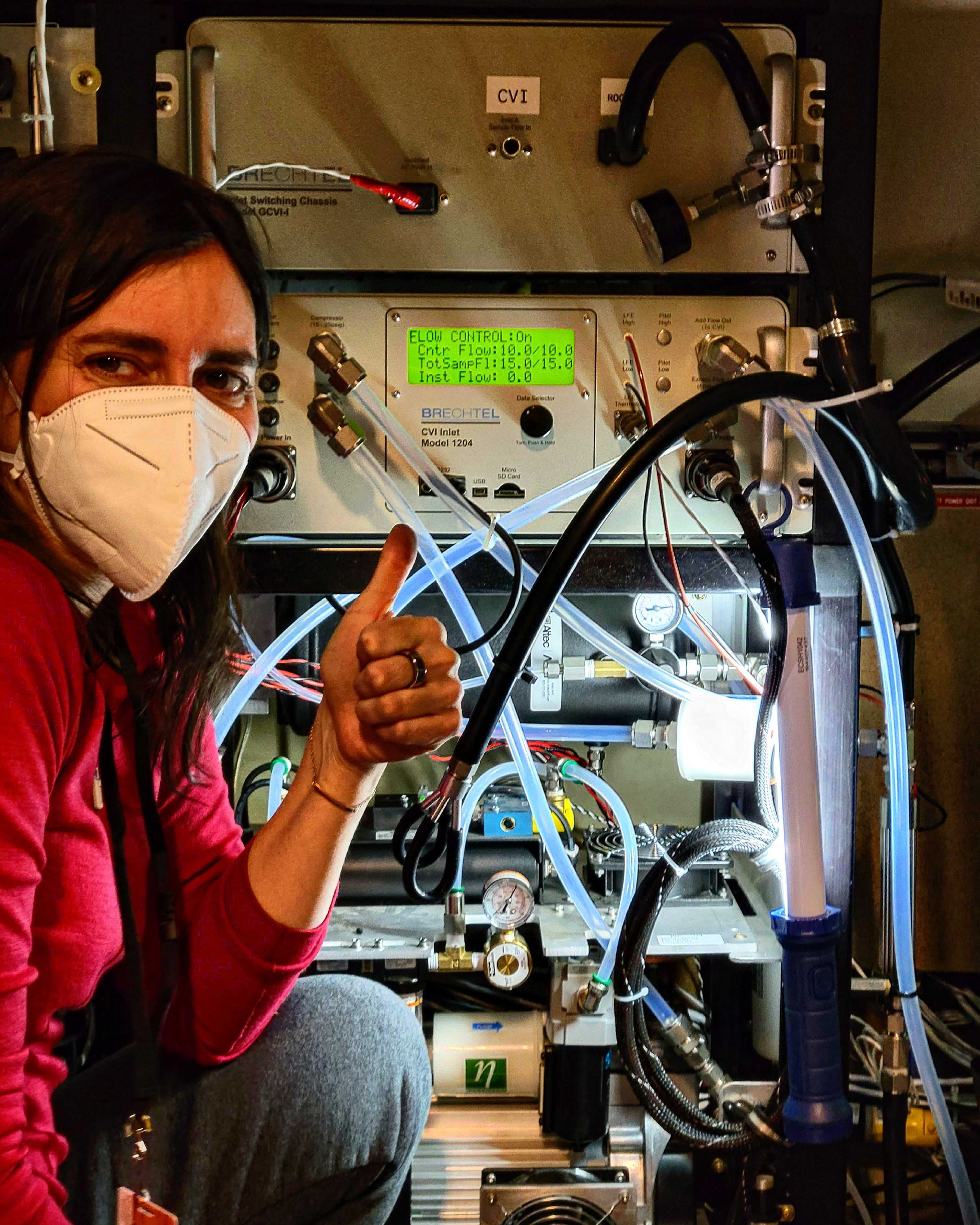 Sara Lance gives a thumbs up from inside a research aircraft while collecting data in the Arctic.