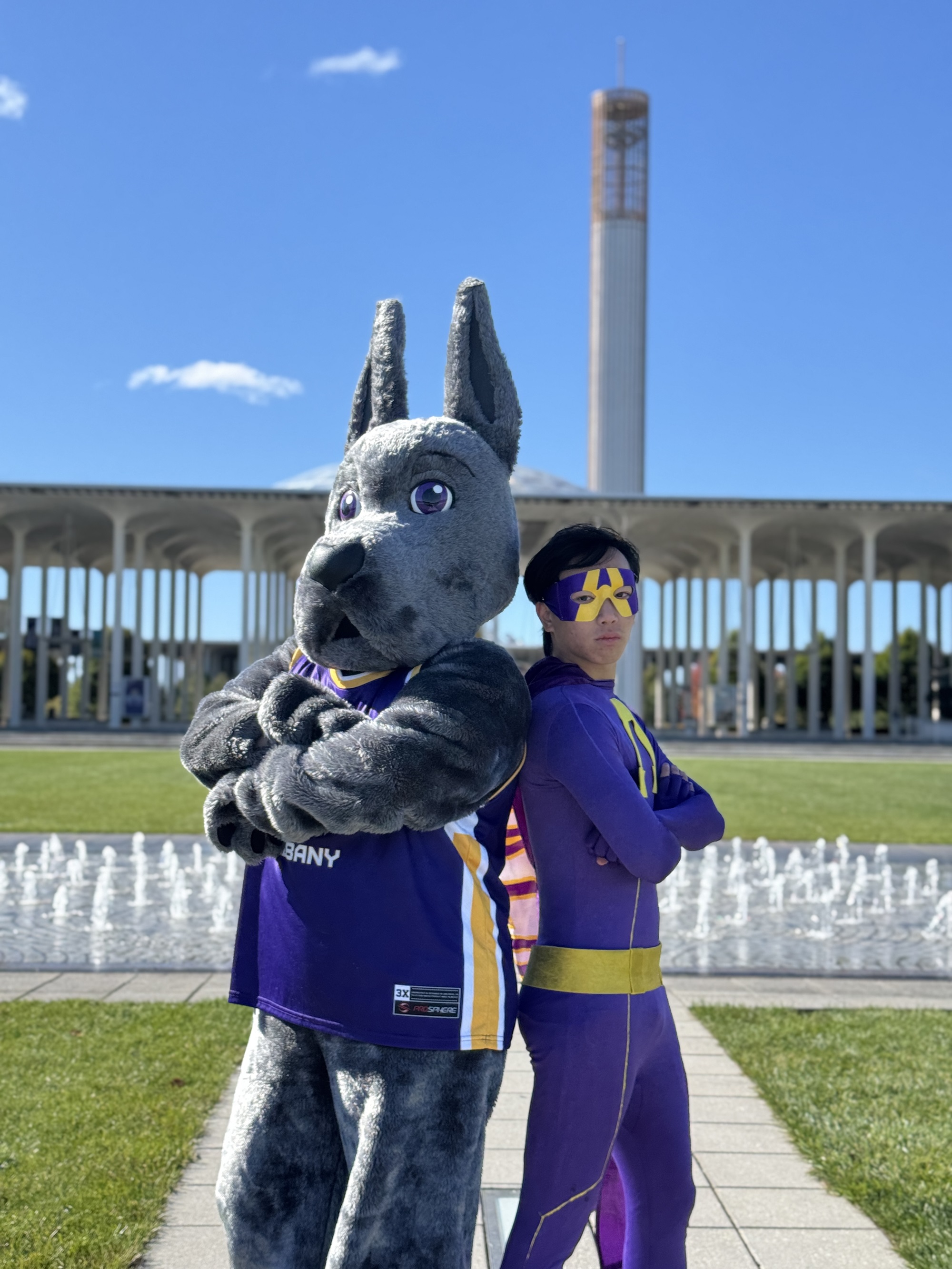 Damien the Great Dane and UAlbany Man stand together on the University Entry Plaza.