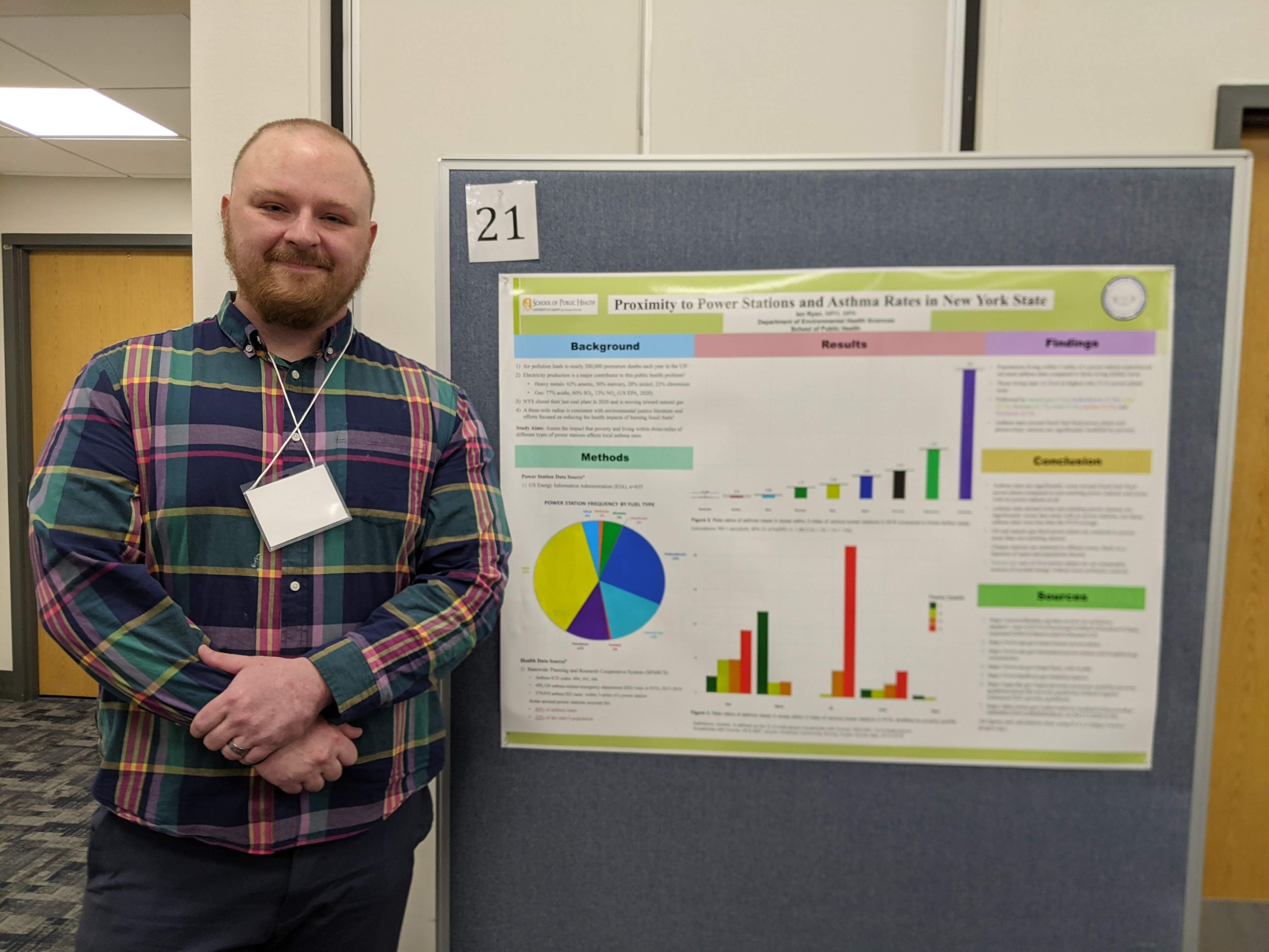 Ian Ryan stands next to his poster on Poster Day.