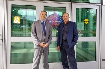 Ray Wickenheiser and Igor Lednev stand for a photo in front of The RNA Institute.   