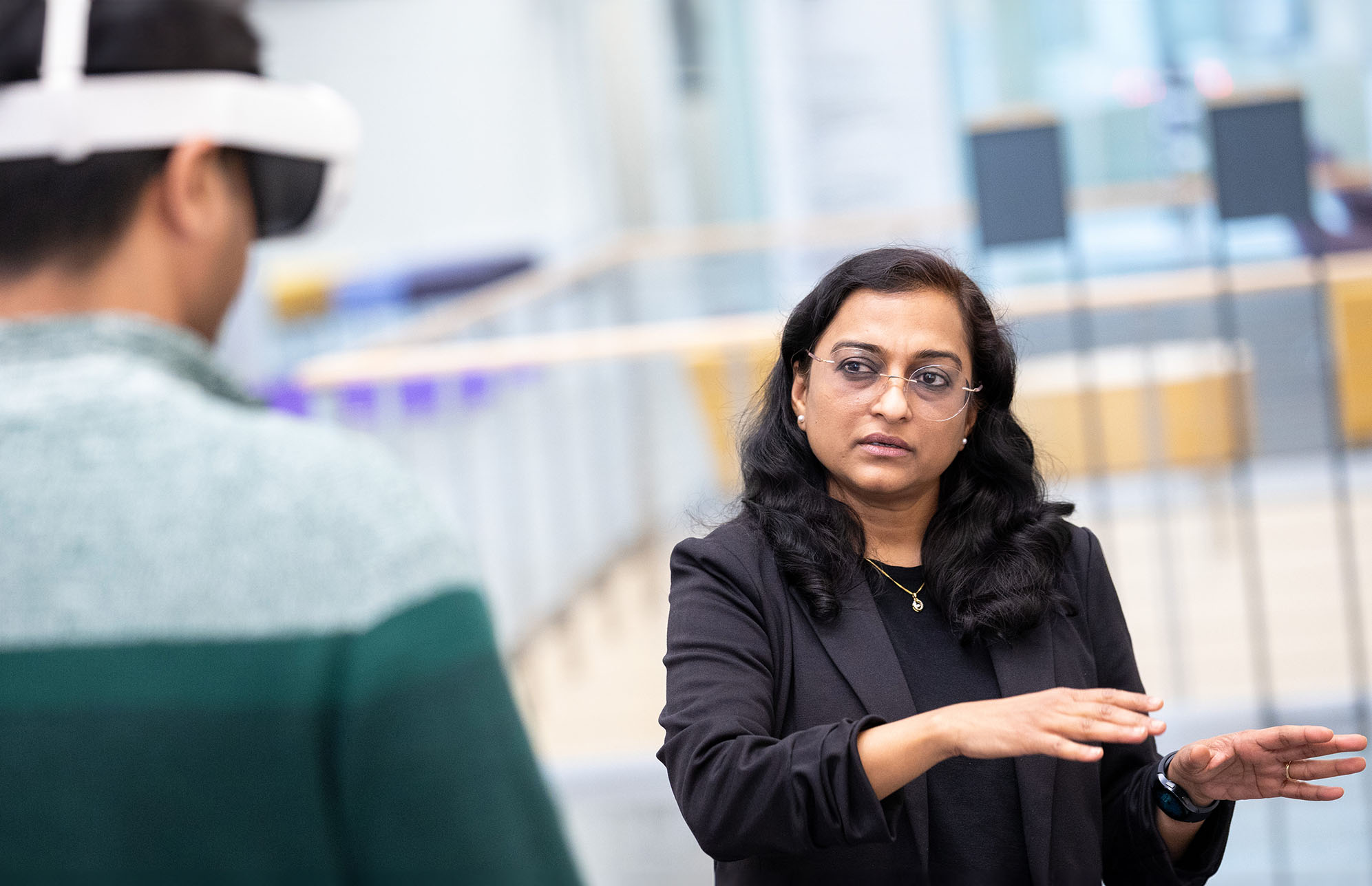 Student wearing a virtual reality headset and working with a faculty member.