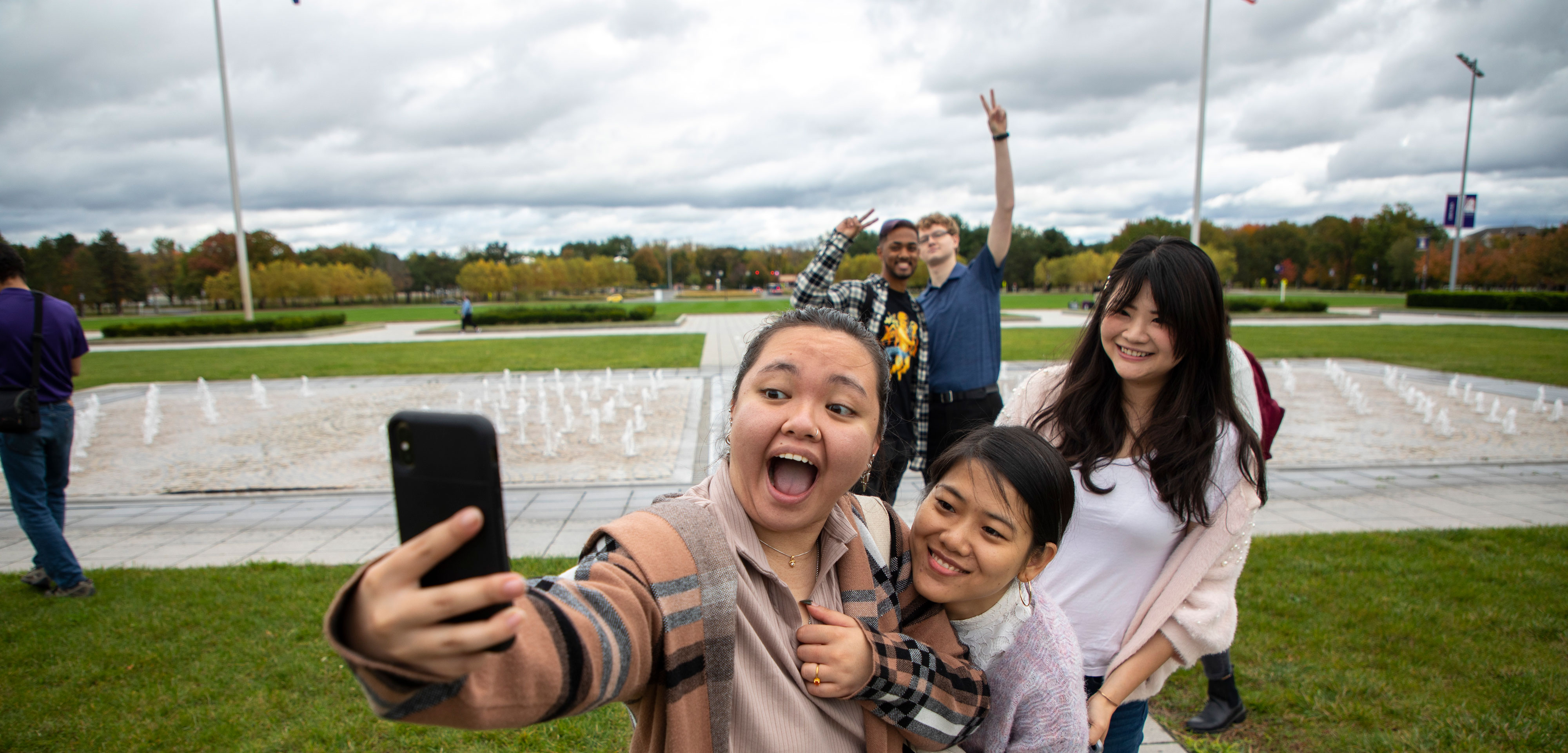 Five students smile and pose for a selfie group photo on UAlbany's Uptown Campus.