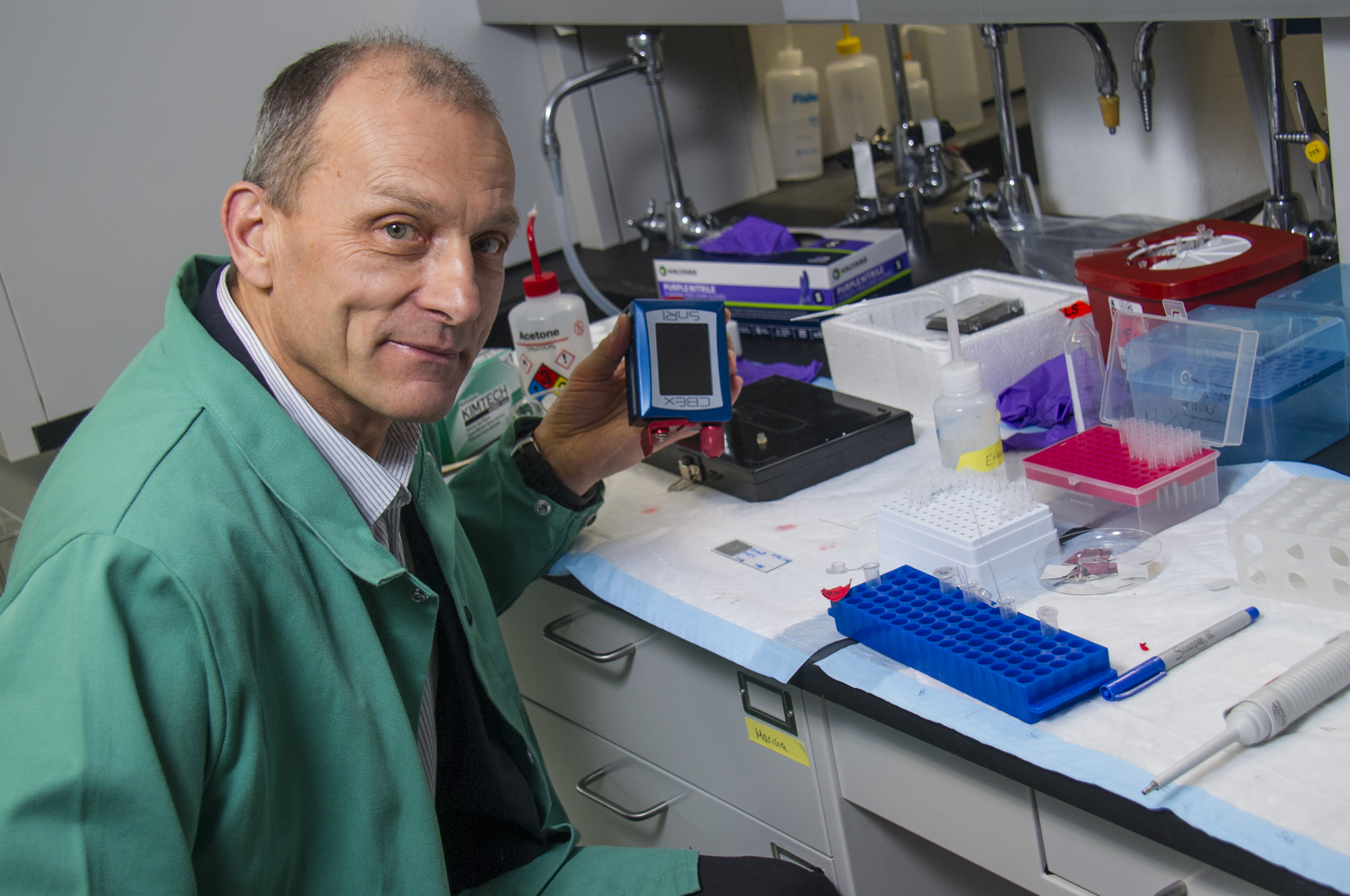 Igor Lednev displays holds a portable Raman spectrometer.