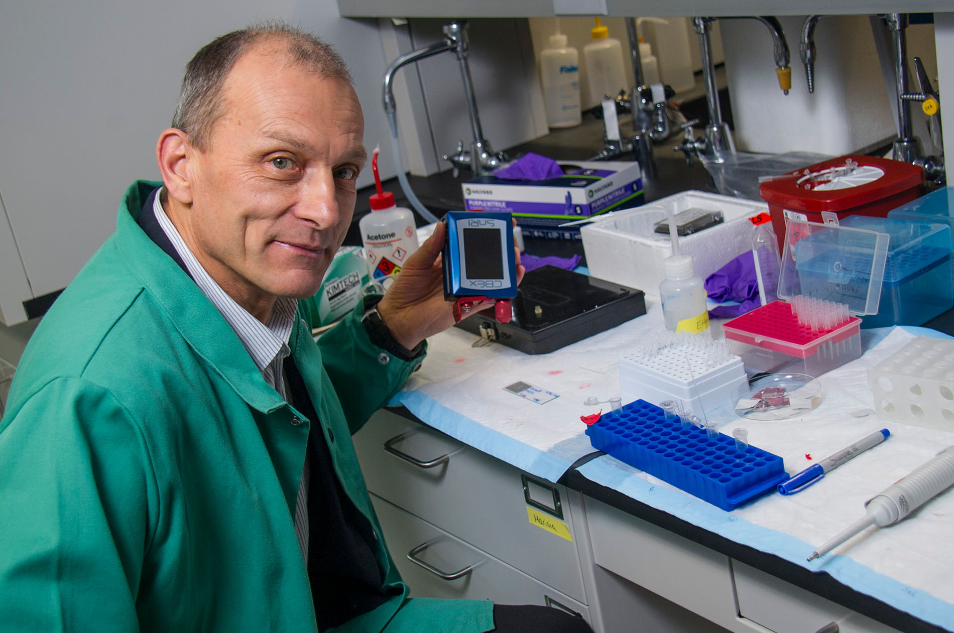 Igor Lednev displays holds a portable Raman spectrometer.