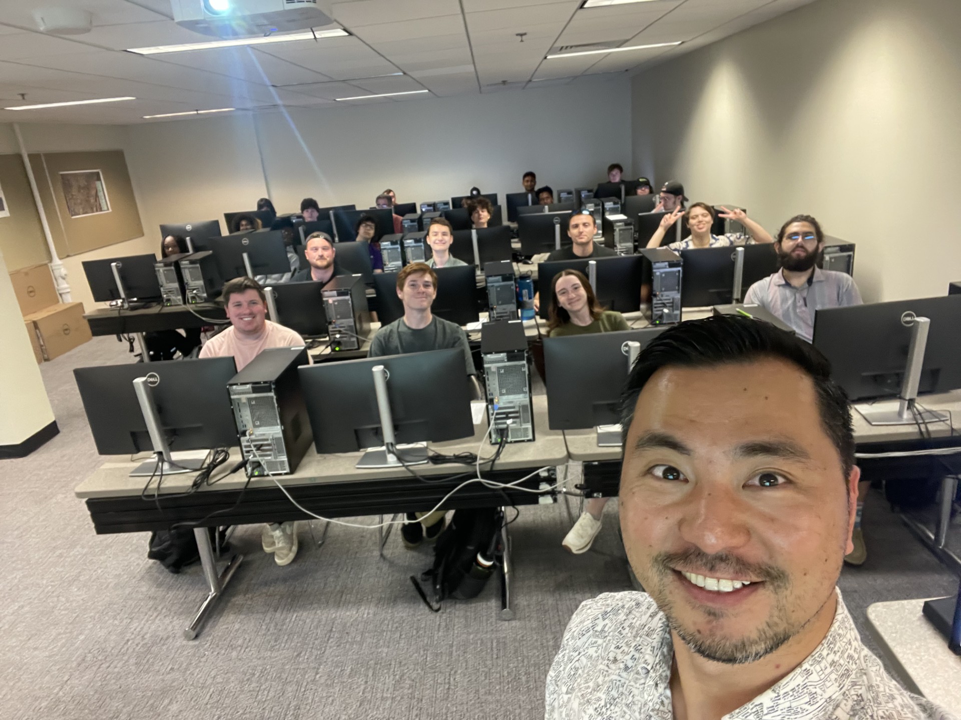 Rui Li takes a selfie with students from a computer lab on campus.