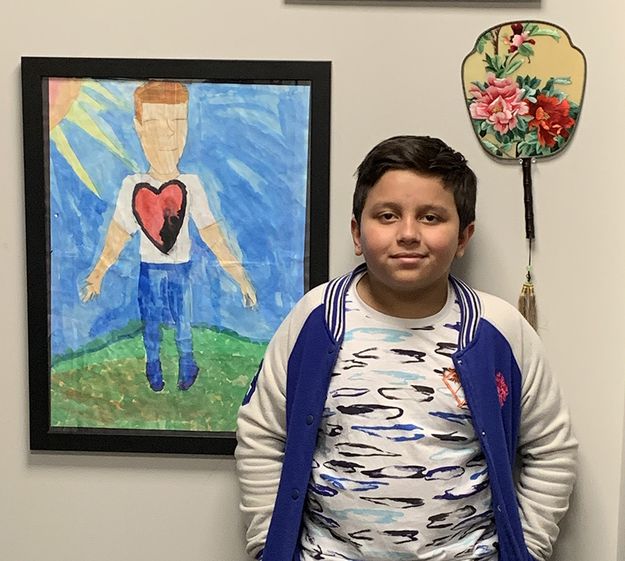Luis Silva of EJ O'Neal Middle School stands next to a poster he created.