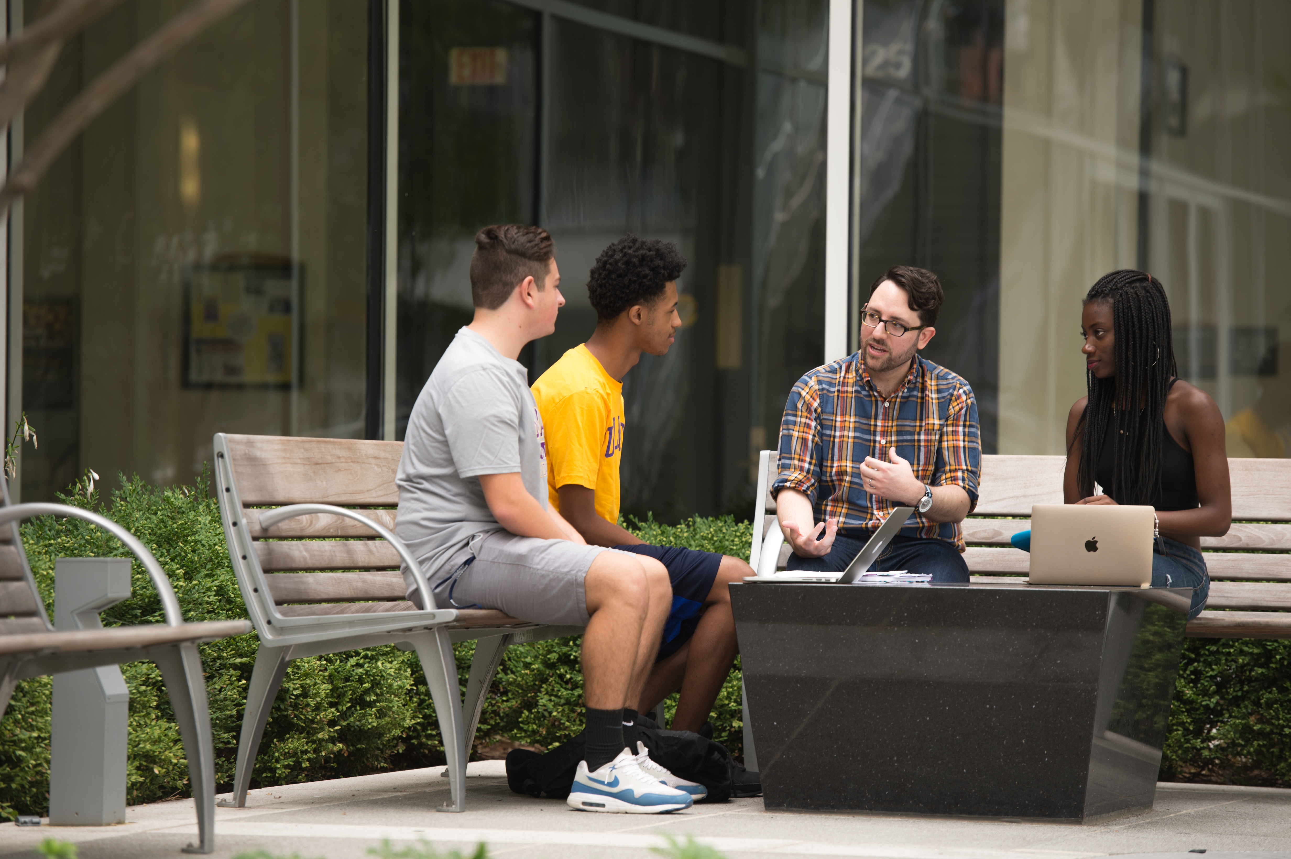 Faculty instructing students in outdoor campus area