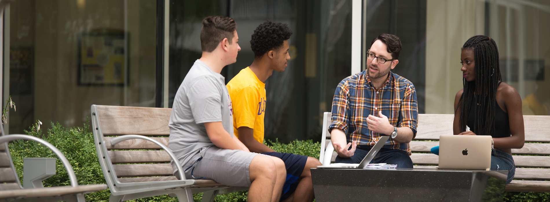 Faculty instructing students in outdoor campus area