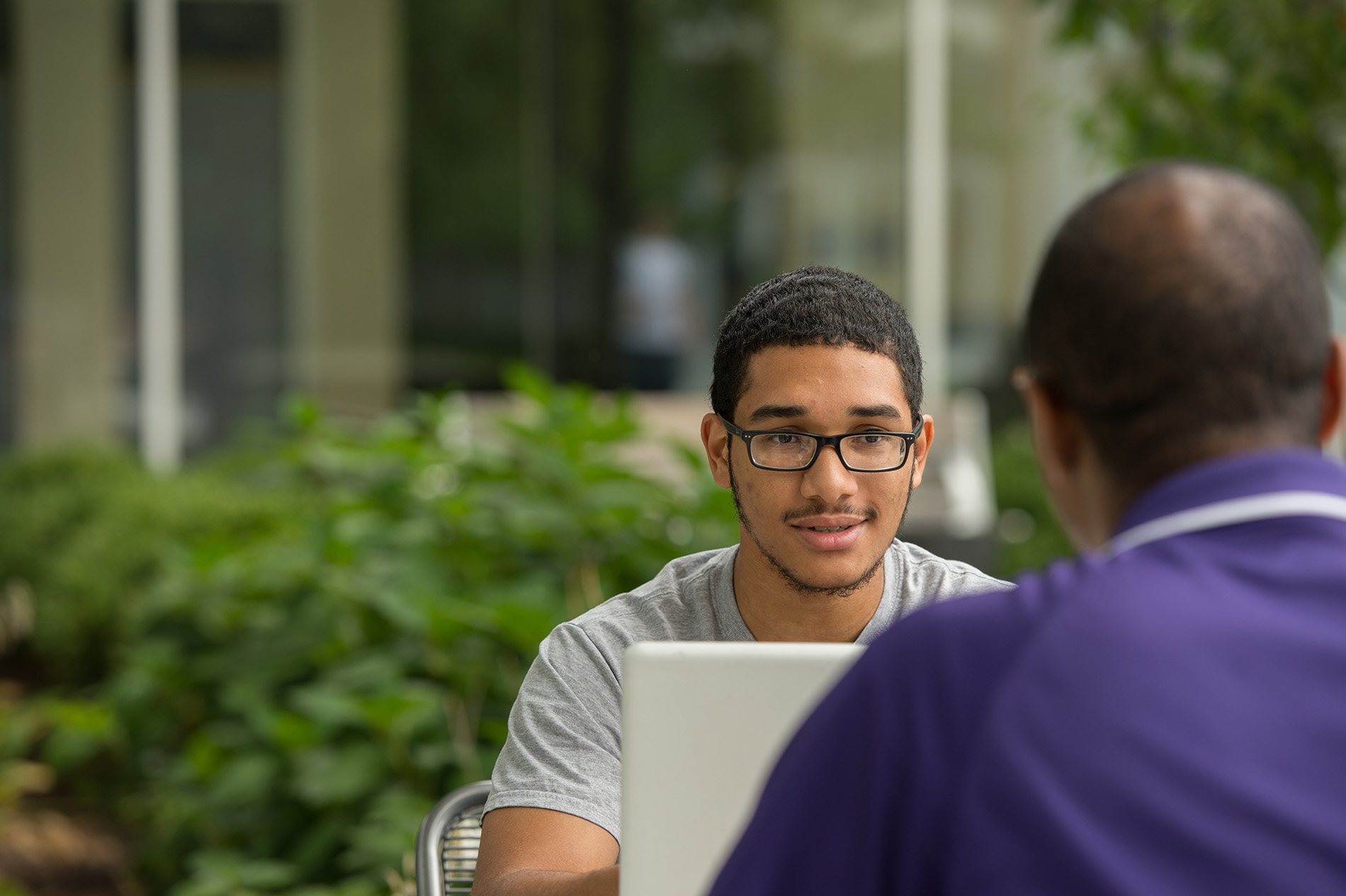 A student meets with an advisor in a courtyard
