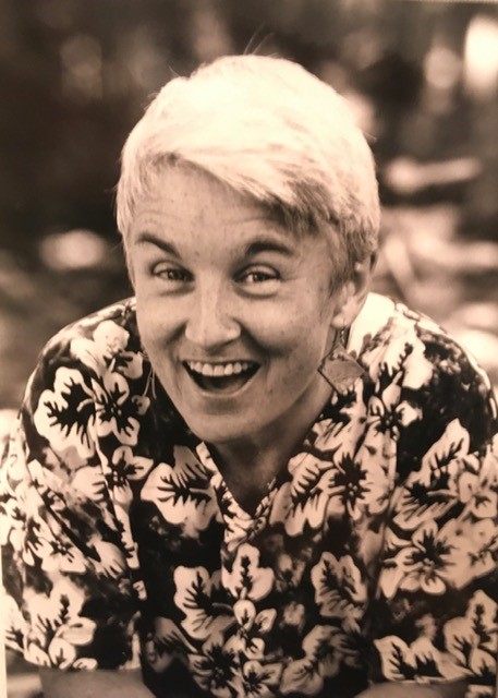 smiling woman with short white hair and flowered shirt