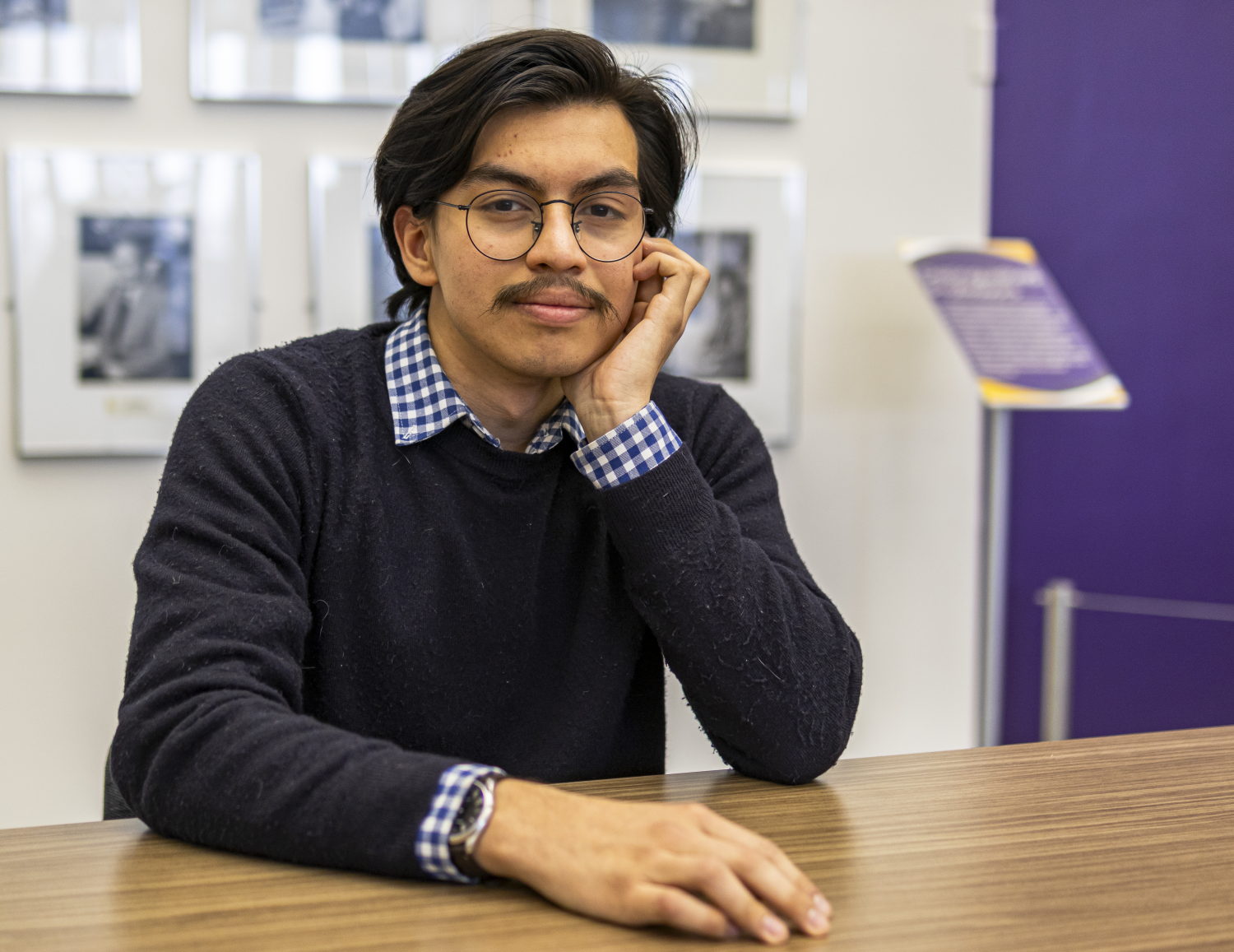 a man in a blue sweater sits at a table