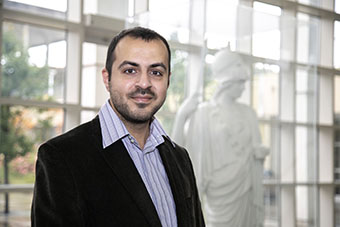 Mustafa Aksoy in  UAlbany's Science Library with Minerva in the background