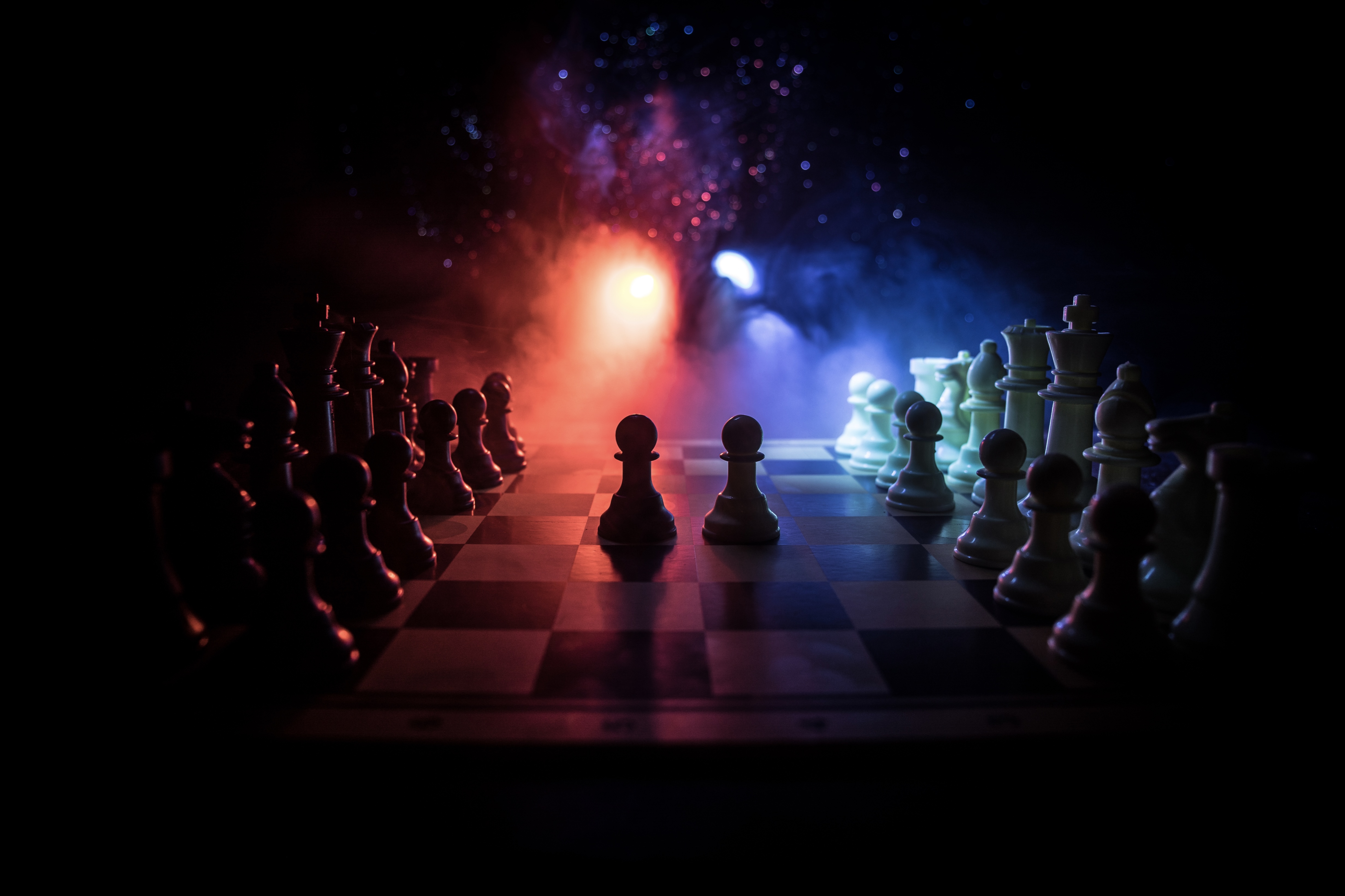 Two chess are highlighted on a chess board with a vibrant light in the background
