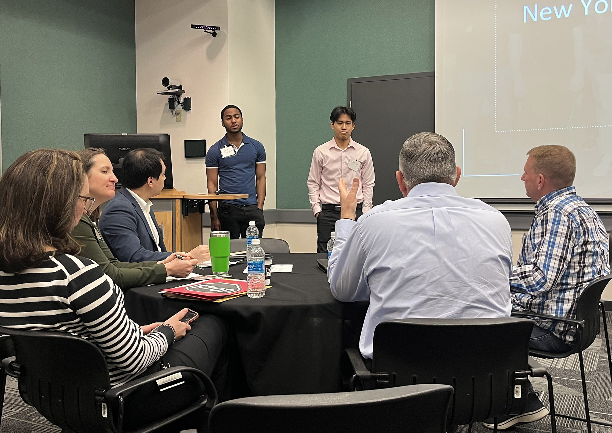 Students Omar Cunningham and Ehdoh Kyi listen to feedback following their presentation at the Capital Regoin Business Competition.