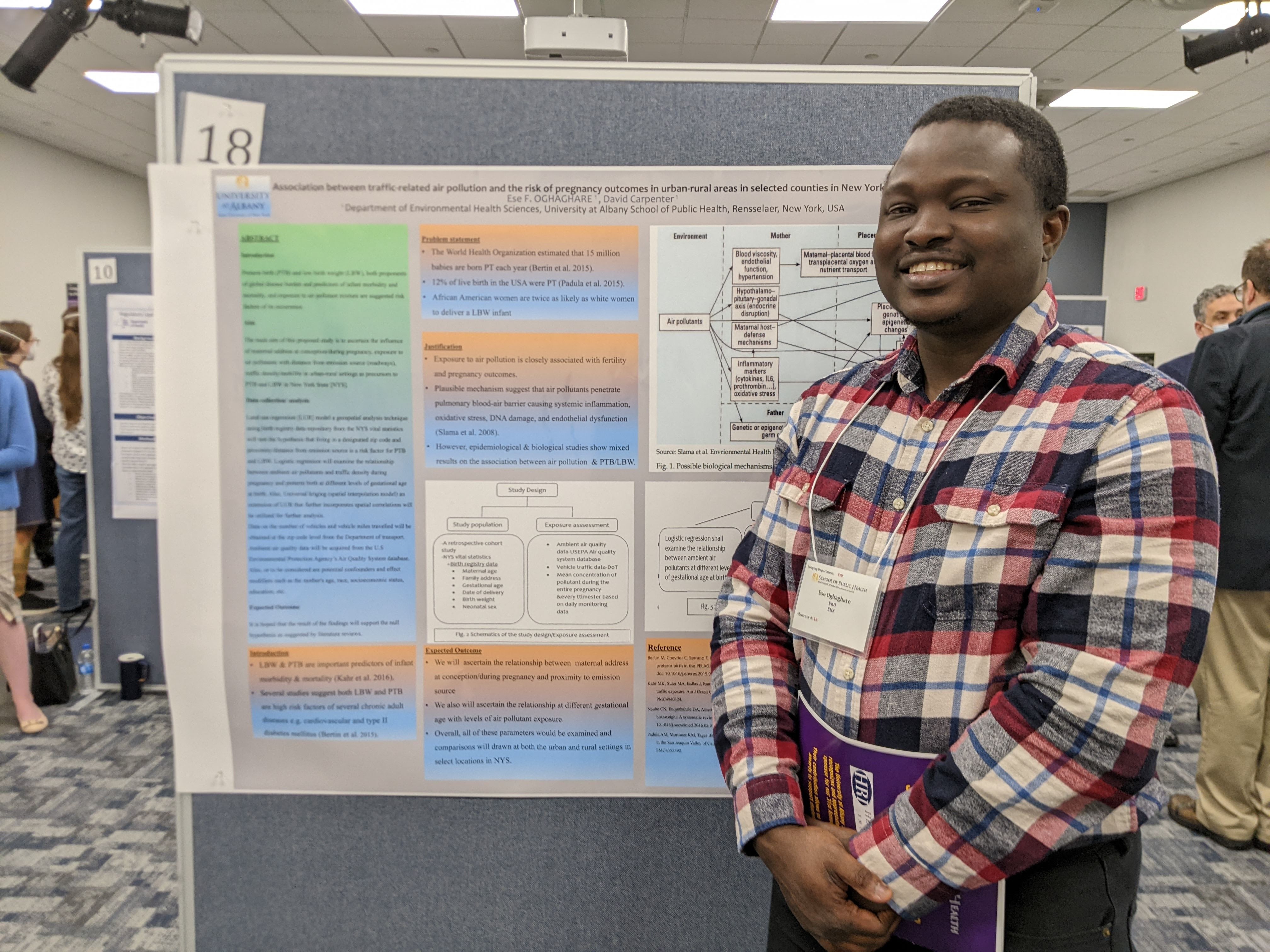 A portrait of Ese next to his poster on Poster Day