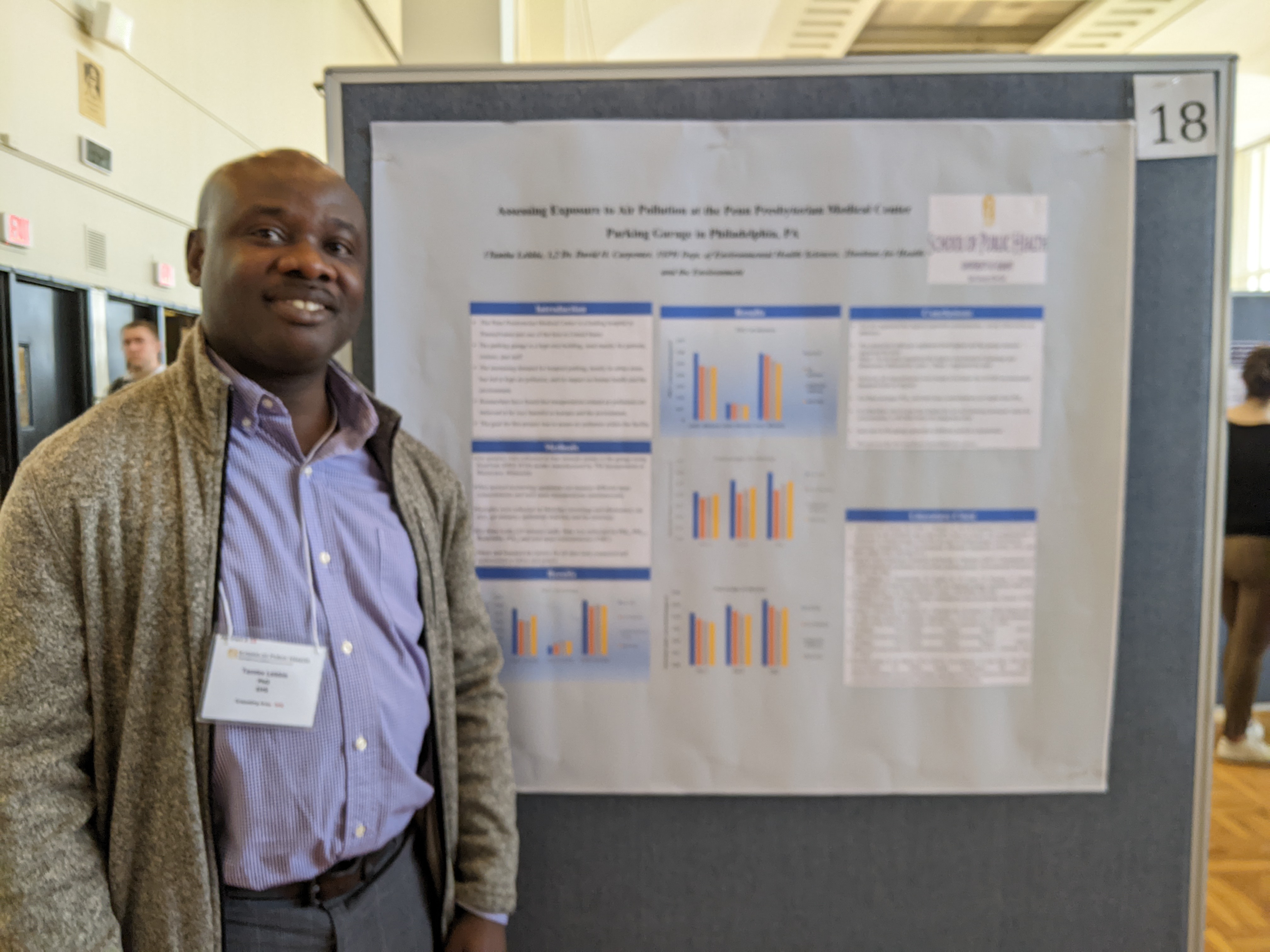Tamba Lebbie stands next to his poster at Poster Day.