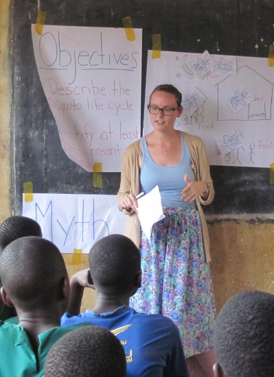 A student stands at the front of a classroom, teaching on her Peace Corps experience.