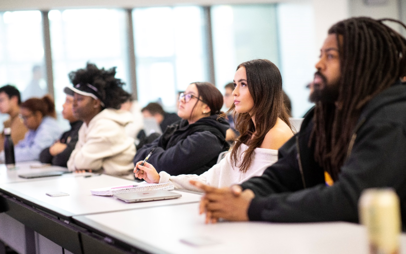 A group of students seated in a classroom taking notes
