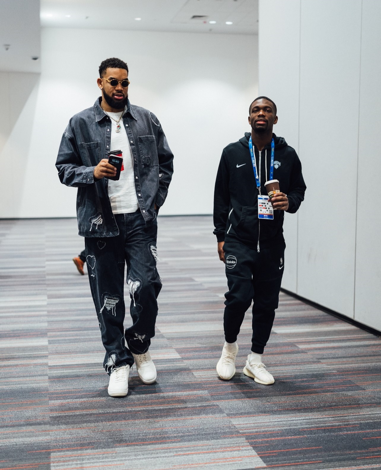 Qadeer Morgan walks through the hallway with New York Knicks player Karl-Anthony Towns.