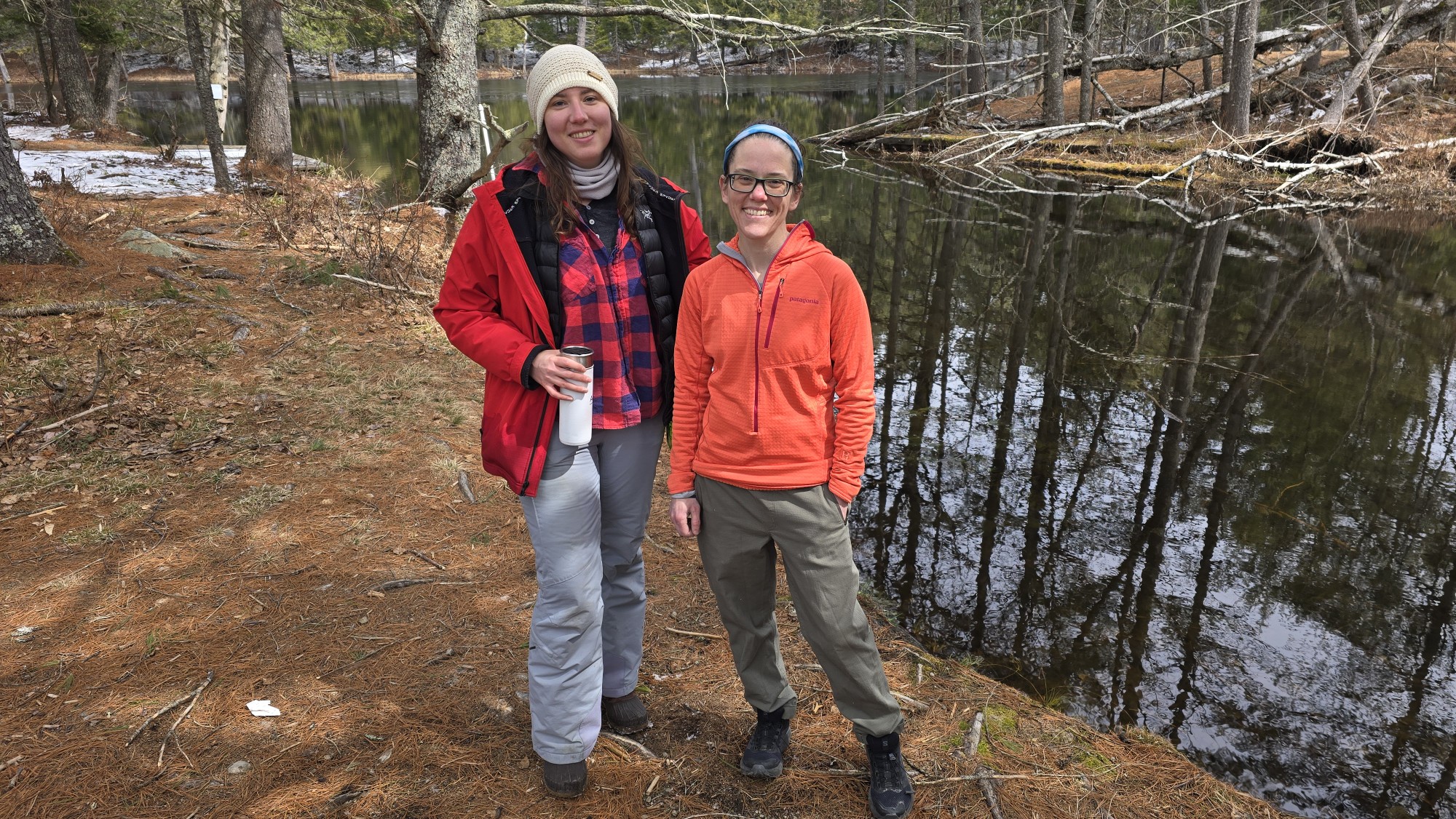 Sky Hooler and Aubrey Hillman stand in front of a pond in the Adirondacks.