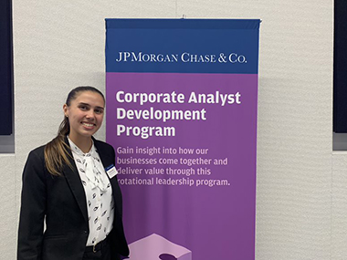 MBA student Christine Rice stands in front of a JPMorgan Chase & Co. banner.