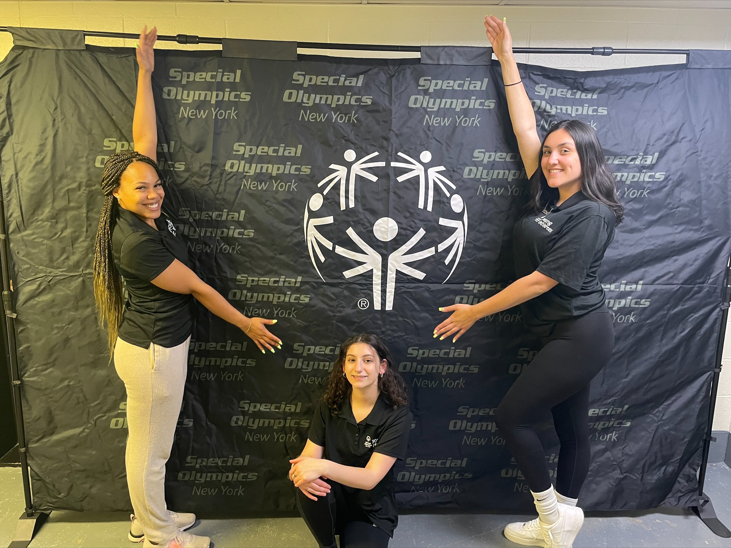 UAlbany student interns stand together to form the Special Olympics logo.