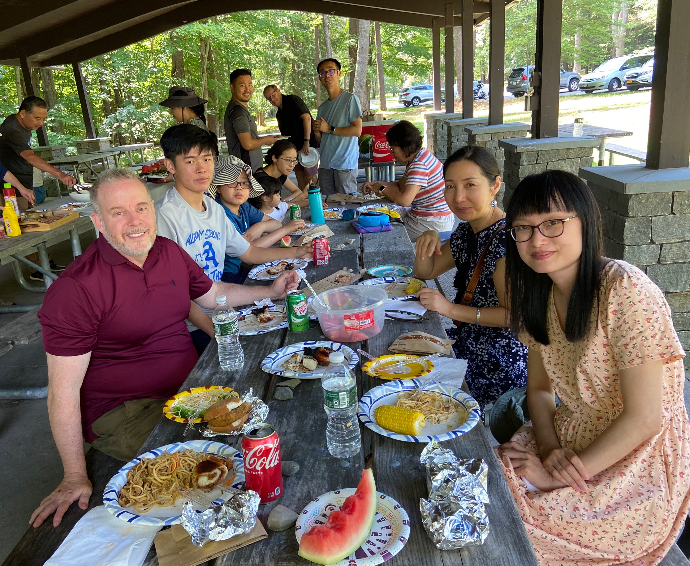 The UAlbany Asian Coalition of Professionals guests sitting at picnic table eating a meal together