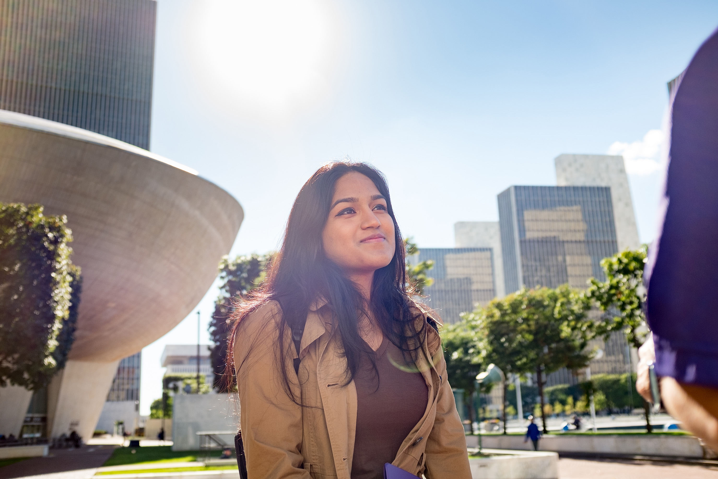 A person walks through Empire Plaza in front of The Egg.