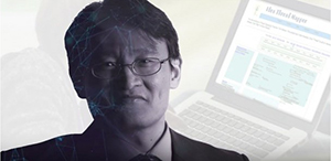 Jianwei Zhang of Educational Theory & Practice smiles in front of a shadowed computer terminal