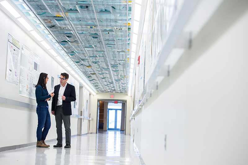 Researchers having a discussion in a hallway on the Health Sciences campus