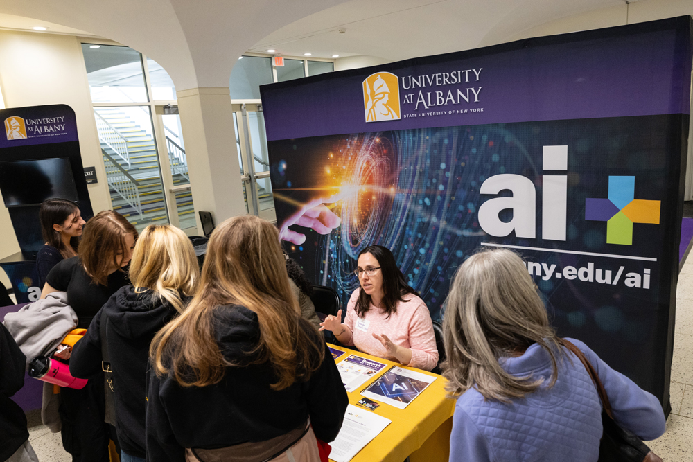 A group of students discussing AI Plus at UAlbany Showcase Day.
