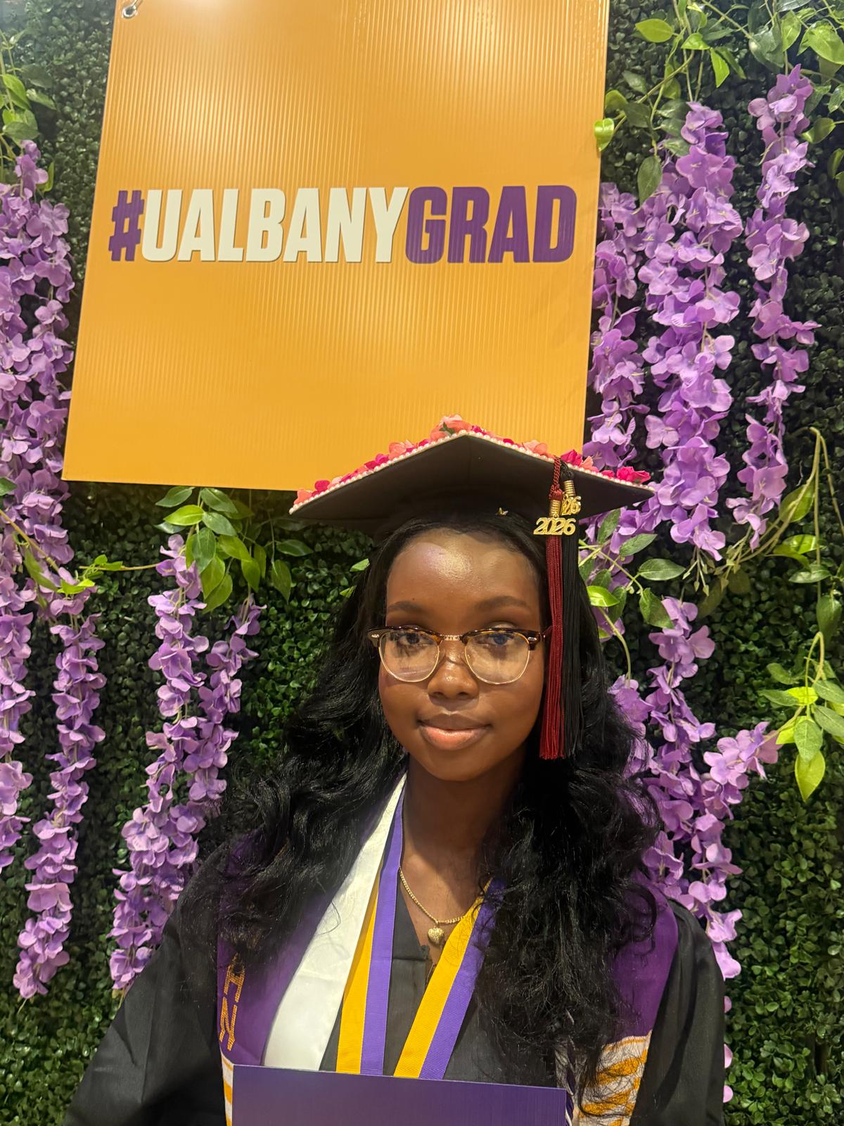Barbara Origene '25 celebrates at UAlbany's 2025 commencement stage crossing event.