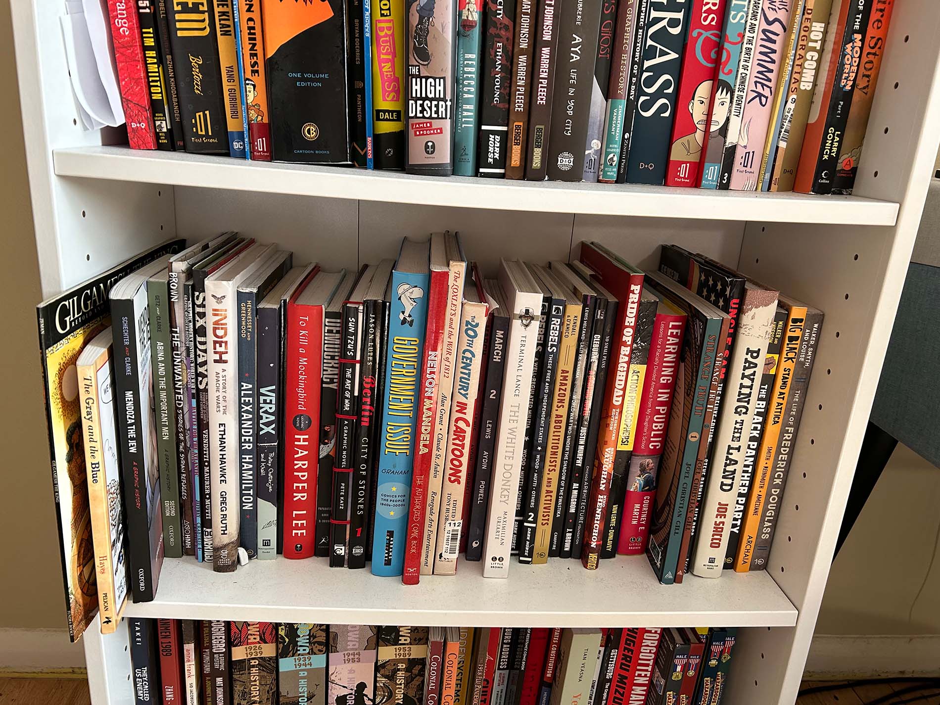 A full bookcase with three shelves of graphic novels. 