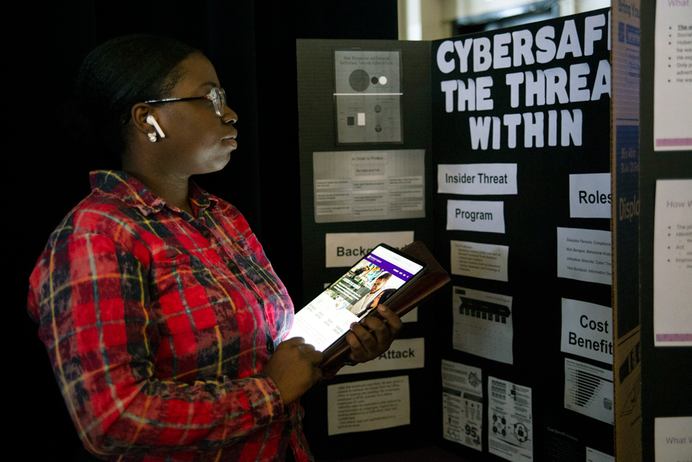 UAlbany student displaying a cybersecurity research project.